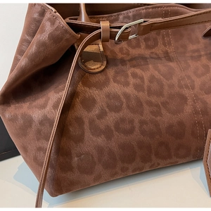 Close-up of leopard print tote bag texture with silver metal buckle and neat stitching