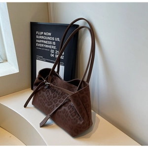 Close-up of leopard print tote bag with silver buckle detail and long shoulder straps