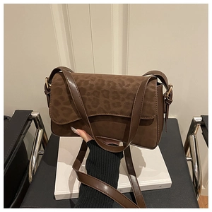 Detail of vintage brown crossbody bag featuring leopard print suede flap and metal buckle