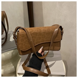 Close-up of brown crossbody bag featuring leopard print suede flap and leather texture