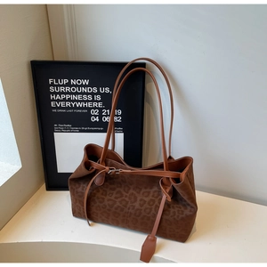 Detail of vintage leopard print tote bag with brown leather straps and metal buckle