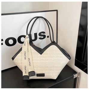 Detail of white woven tote bag with V-shaped cutout, black leather trim and silk ribbon