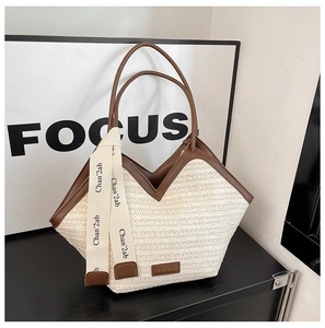 Detail of woven straw tote bag with brown leather trim and stylish canvas ribbon accent