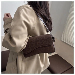 Detail of vintage leopard print matte shoulder bag worn over a khaki trench coat