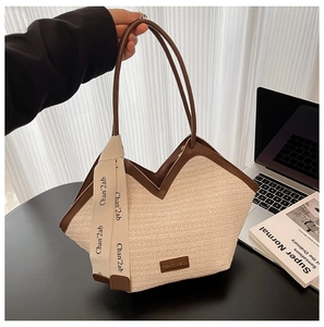 Detail of woven tote bag with V-shaped opening, brown leather trim and stylish ribbon