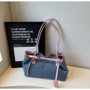 Detail of the leopard print blue tote bag with pink straps and metallic buckle accent