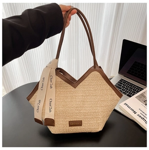 Detail of hand-woven straw tote with contrast leather trim and chic silk scarf handle décor