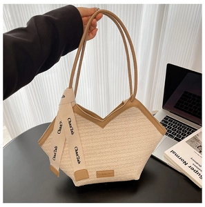 Detail of woven tote bag with camel leather trim and stylish printed decorative silk scarf