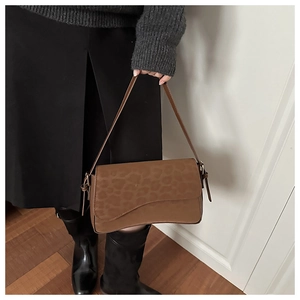 Close-up of brown leopard print crossbody bag with wave flap and thin shoulder strap