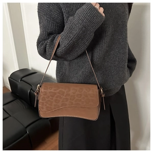 Close-up of leopard print shoulder bag with wavy flap design and slim leather strap