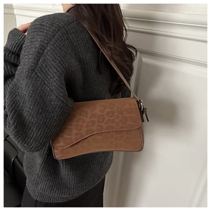 Detailed view of brown leopard print baguette bag with matte texture and slim strap