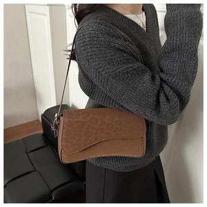 Detail of leopard print matte shoulder bag with unique wavy flap and leather strap