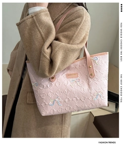 Close-up of pink tote bag with diamond lattice pattern and sequined bow detail