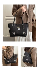 Detail of black tote bag featuring colorful bow embroidery and quilted letter texture