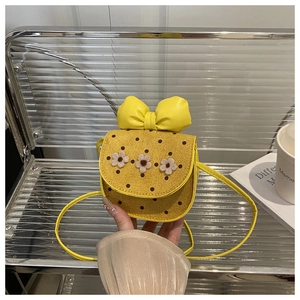 Détail du sac bandoulière jaune pour fille avec pois marrons, nœud et ornements de fleurs