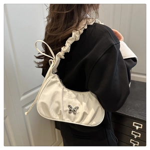 Detail of white nylon crescent bag with silver butterfly buckle and ruched strap