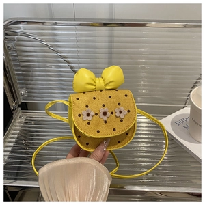 Détail d'un sac jaune pour filles avec fleurs en 3D et un grand nœud décoratif