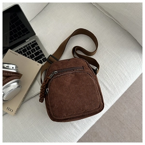 Détail du petit sac bandoulière en velours côtelé marron avec poche zippée