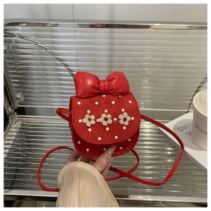 Détail du sac bandoulière rouge à pois avec grand nœud et fleurs décoratives