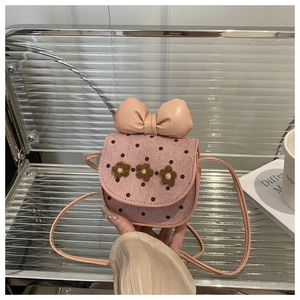 Détail du sac enfant rose à pois avec grand nœud en cuir et décors floraux en relief