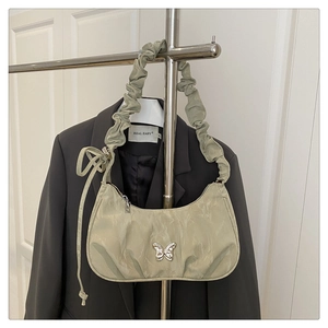 Detail of sage green crescent bag with silver butterfly and scrunchie strap