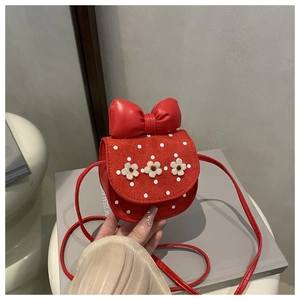 Détail du sac bandoulière rouge pour enfant avec gros nœud et fleurs 3D blanches