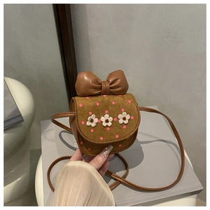 Détail du mini sac bandoulière marron avec pois roses, fleurs blanches et grand nœud en cuir