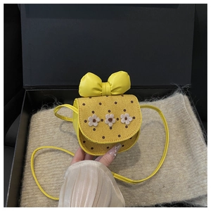 Détail du mini sac bandoulière jaune pour enfant avec rabat en daim à pois et fleurs