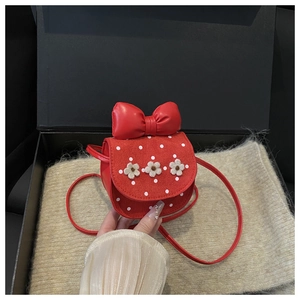 Détail du mini sac bandoulière rouge pour filles avec pois blancs et accents fleuris