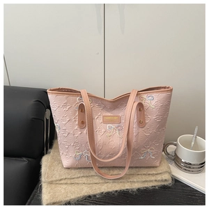 Close-up of pink tote bag with colorful butterfly embroidery and quilted texture
