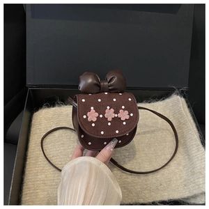 Vue détaillée du mini sac bandoulière marron avec fleurs roses et nœud décoratif