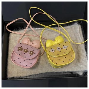 Gros plan sur les sacs bandoulière à pois roses et jaunes avec nœud et fleurs