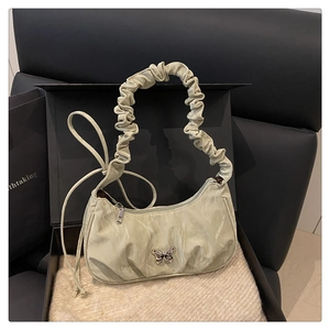 Detail of sage green ruched shoulder bag with silver butterfly buckle in a gift box
