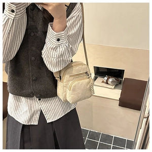 Petit sac bandoulière vertical en velours côtelé crème avec sangle réglable sur modèle