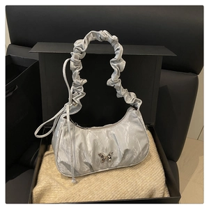 Detail of light grey pleated shoulder bag featuring a silver metal butterfly buckle accent