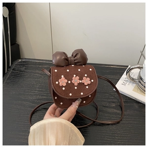 Détail d'un sac bandoulière marron avec pois blancs, broderies fleurs et un grand nœud