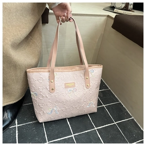 Pink tote bag with embossed E pattern and sequined bow shown in a casual lifestyle scene