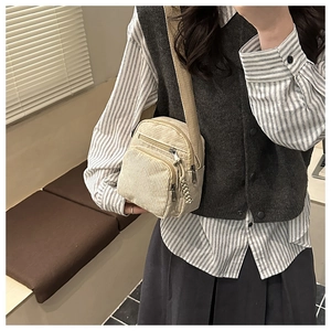 Détail du sac bandoulière beige en velours côtelé avec sangle réglable et poches