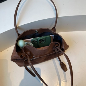Large dark brown faux leather tote bag with long shoulder straps and spacious storage