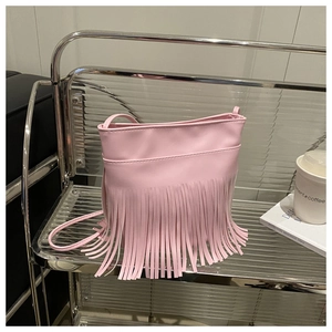 Detailed view of pink crossbody bag with long fringes and slender shoulder strap