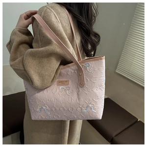 Detailed back view of a pink quilted tote bag with colorful embroidered bow patterns