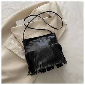 Detailed close-up of a black crossbody bag featuring long fringes and PU leather texture