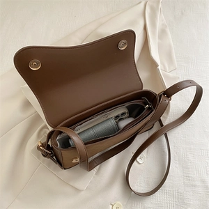 Brown vintage suede crossbody bag with magnetic flap and inner compartments shown from 45-degree angle