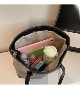 Top view of spacious black tote bag interior showing capacity for tablet and daily items