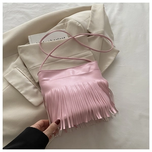 Macro detail of pink synthetic leather handbag featuring long vertical fringe tassels