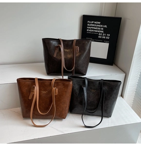 Three retro faux leather tote bags in dark brown, caramel, and grey on white steps