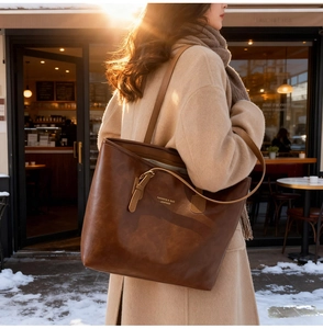 Close-up of vintage brown oil wax leather tote bag with elegant gold foil lettering details