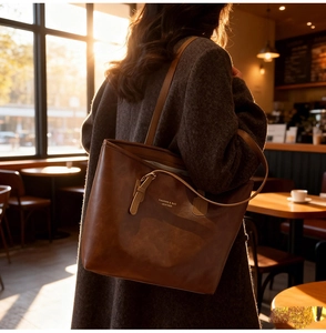 Detail of vintage brown leather tote bag with gold lettering in sunset light