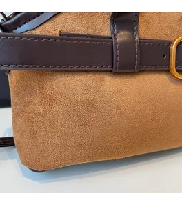 Détail de sac en daim marron avec bandoulière en cuir et boucle dorée vintage