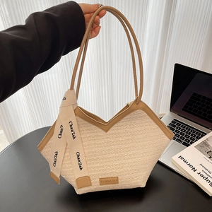 Chic woven tote bag with brown leather trim and silk scarf on a desk with a laptop